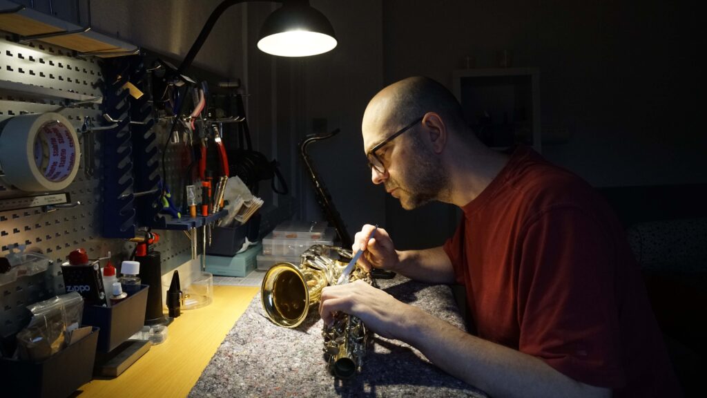 Morten reparerer en saxofon i sit værksted, Det Lille Saxofonværksted i Odense
